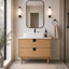 Bathroom vanity with wooden cabinet, white sink, and mirror in a modern setting.