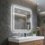 Bathroom vanity with illuminated mirror against a stone wall.