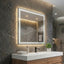 Bathroom vanity with illuminated mirror against a stone wall.