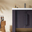 Bathroom vanity with dark cabinet, white countertop, and decorative items on a beige wall.