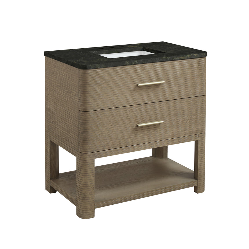 A modern bathroom vanity with a light oak wood frame, six drawers, an open lower shelf, and a white marble top with an integrated sink. The vanity is styled in a bright bathroom with a white freestanding tub, a gold faucet, and a glass shower stall in the background.