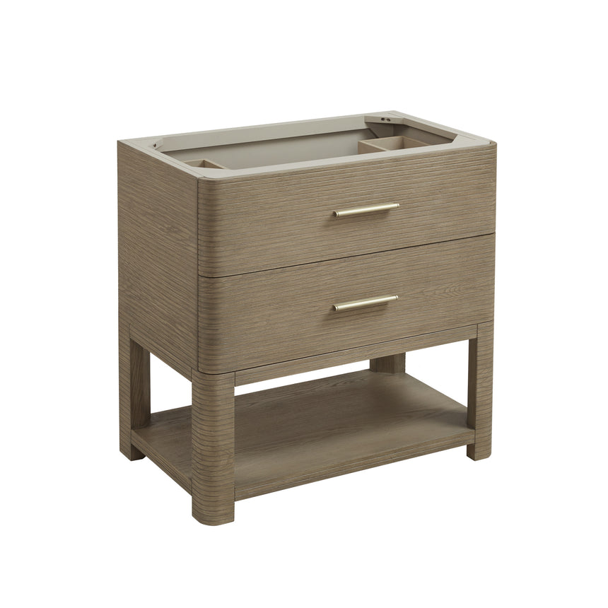 A modern bathroom vanity with a light oak wood frame, six drawers, an open lower shelf, and a white marble top with an integrated sink. The vanity is styled in a bright bathroom with a white freestanding tub, a gold faucet, and a glass shower stall in the background.