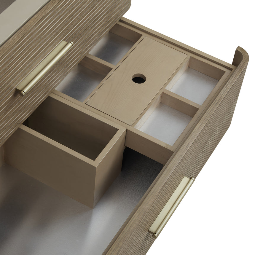 A modern bathroom vanity with a light oak wood frame, six drawers, an open lower shelf, and a white marble top with an integrated sink. The vanity is styled in a bright bathroom with a white freestanding tub, a gold faucet, and a glass shower stall in the background.