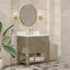 Bathroom vanity with round mirror, lights, and plant in a tiled room.