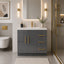 Bathroom interior with a gray vanity unit, gold fixtures, and a mirror.