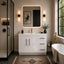 Modern bathroom with white vanity, mirror, and bathtub.