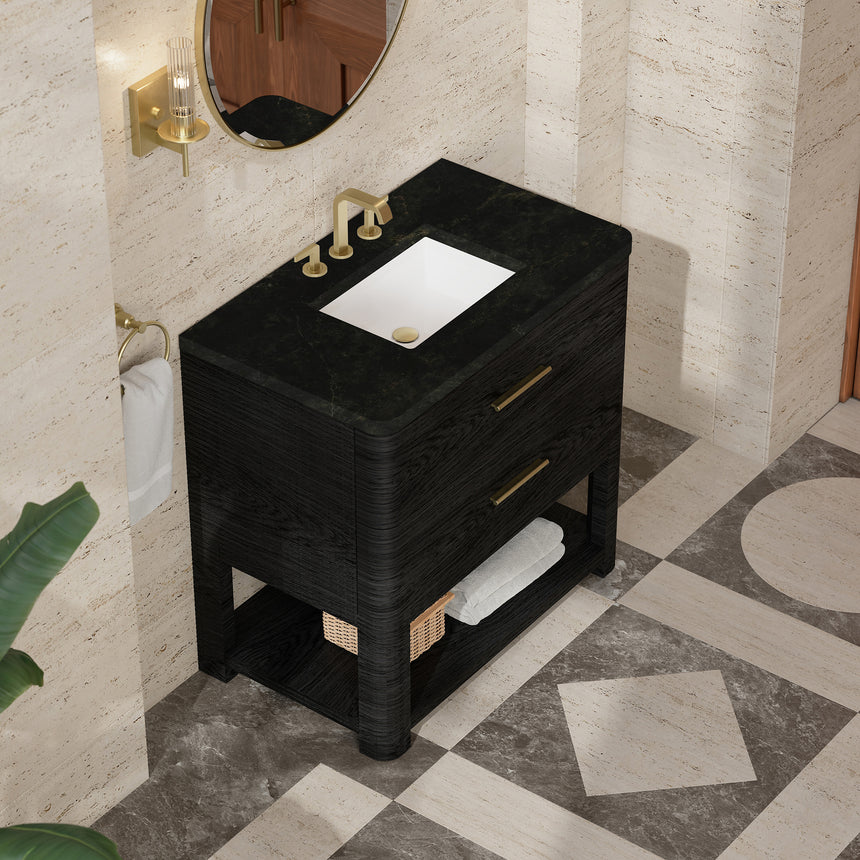 A modern bathroom vanity with a light oak wood frame, six drawers, an open lower shelf, and a white marble top with an integrated sink. The vanity is styled in a bright bathroom with a white freestanding tub, a gold faucet, and a glass shower stall in the background.