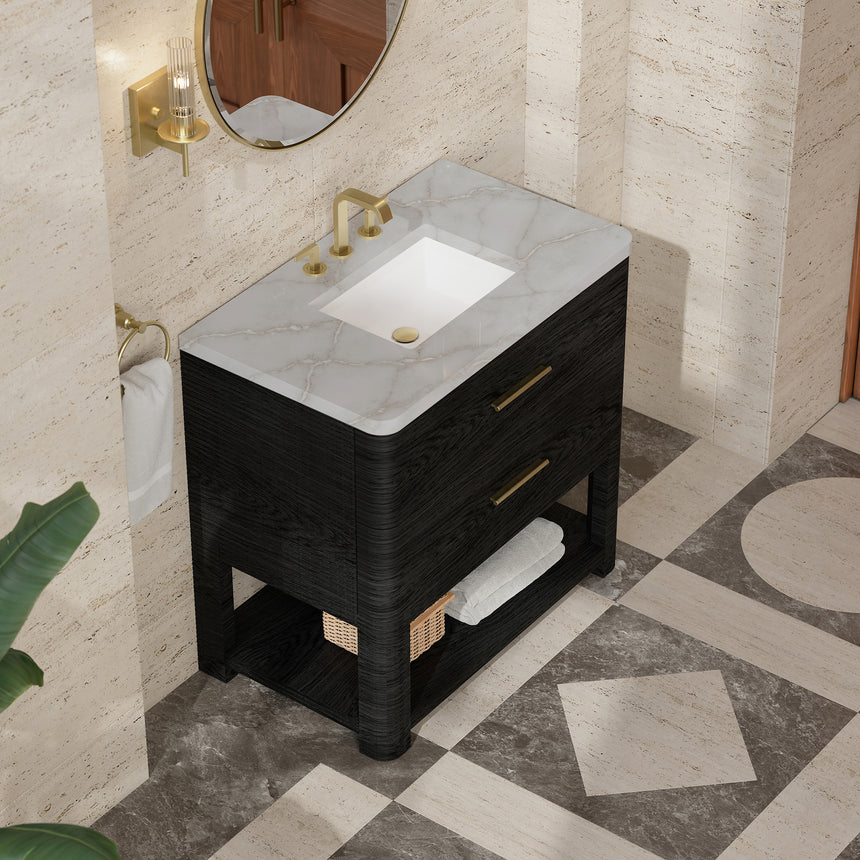A modern bathroom vanity with a light oak wood frame, six drawers, an open lower shelf, and a white marble top with an integrated sink. The vanity is styled in a bright bathroom with a white freestanding tub, a gold faucet, and a glass shower stall in the background.