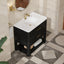 Bathroom vanity with white sink and black cabinet in a tiled bathroom.