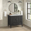 Bathroom vanity with round mirror, sink, and decorative elements in a well-lit room.