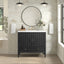 Bathroom vanity with black cabinet, round mirror, and decorative elements.