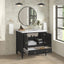 Bathroom vanity with open cabinet, round mirror, and window in the background