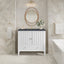 Bathroom with white vanity, round mirror, and decorative elements.