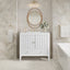 Bathroom with white vanity, round mirror, and decorative elements.