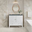 Bathroom with white vanity, round mirror, and decorative elements.