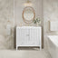 Bathroom with white vanity, round mirror, and bathtub.