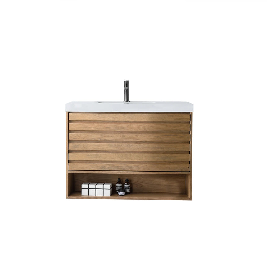 A modern floating bathroom vanity with a light oak wood finish, a white countertop, and an integrated sink, shown in a styled bathroom setting with a bathtub, shower glass, and decorative plants.