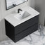 Bathroom vanity with white countertop and black drawers on a marble floor.