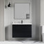 Bathroom vanity with black cabinet and white countertop against a gray wall.