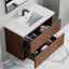 Bathroom vanity with open drawers containing towels, on a marble floor.