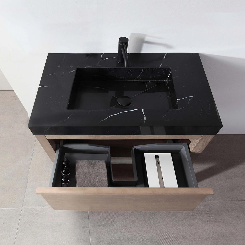 Bathroom vanity with black countertop and wooden cabinet in a bright room.