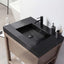 Bathroom vanity with black countertop and faucet, featuring a soap dispenser and toothbrush holder.