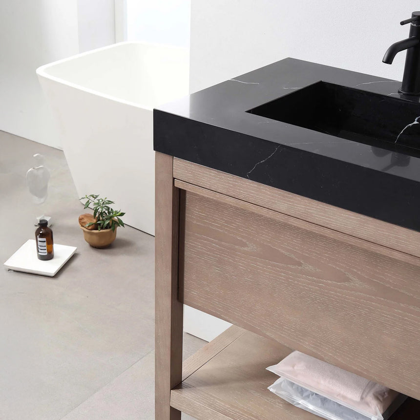 Bathroom vanity with black countertop and wooden cabinet in a bright room.