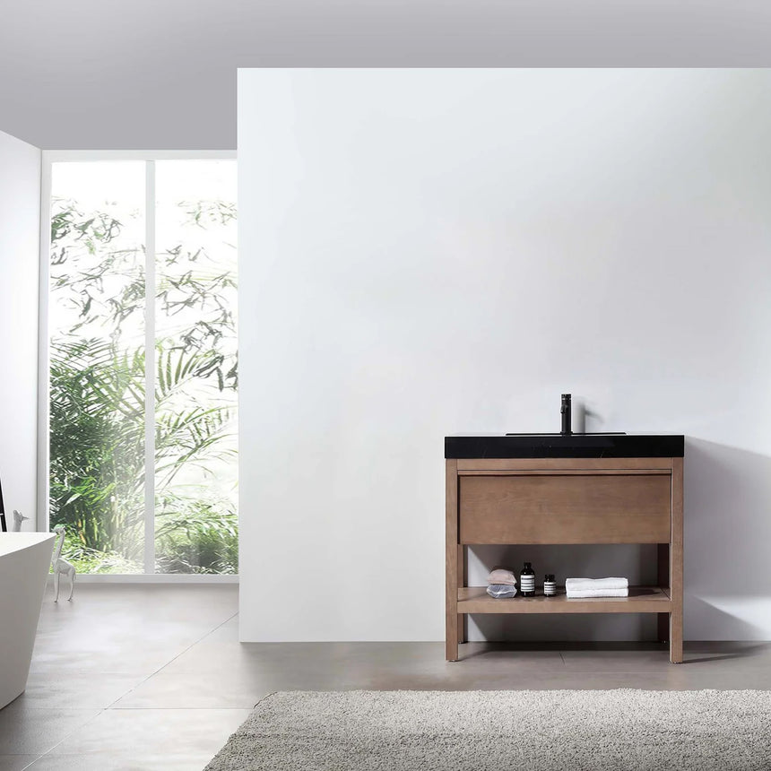 Bathroom vanity with black countertop and wooden cabinet in a bright room.