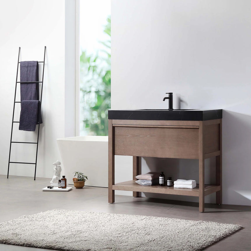 Bathroom vanity with black countertop and wooden cabinet in a bright room.