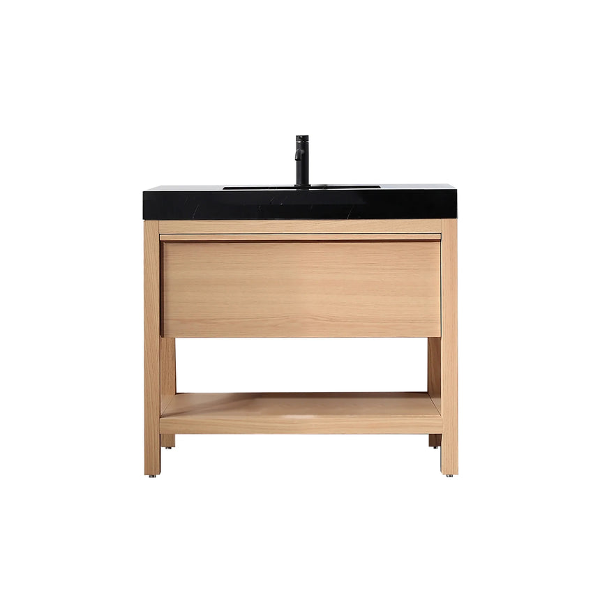 Bathroom vanity with black countertop and wooden cabinet in a bright room.