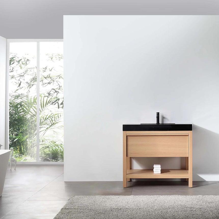 Bathroom vanity with black countertop and wooden cabinet in a bright room.