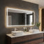 Bathroom vanity with a large illuminated mirror, two sinks, and decorative elements.