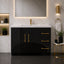 Modern bathroom with black vanity, gold fixtures, and marble walls.