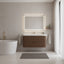 Modern bathroom with a freestanding bathtub, wooden vanity, and illuminated mirror.
