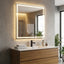 Bathroom vanity with illuminated mirror, sink, and decorative items.