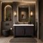 Modern bathroom with dark vanity, mirror, and lighting fixtures.