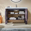 Bathroom vanity with open cabinet doors displaying toiletries and towels against a beige wall.