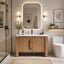 Modern bathroom with wooden vanity, mirror, and toilet.