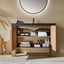 Bathroom vanity with open cabinet displaying toiletries against a beige wall.
