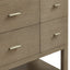 Close-up of a wooden bathroom vanity with four drawers and metallic handles.