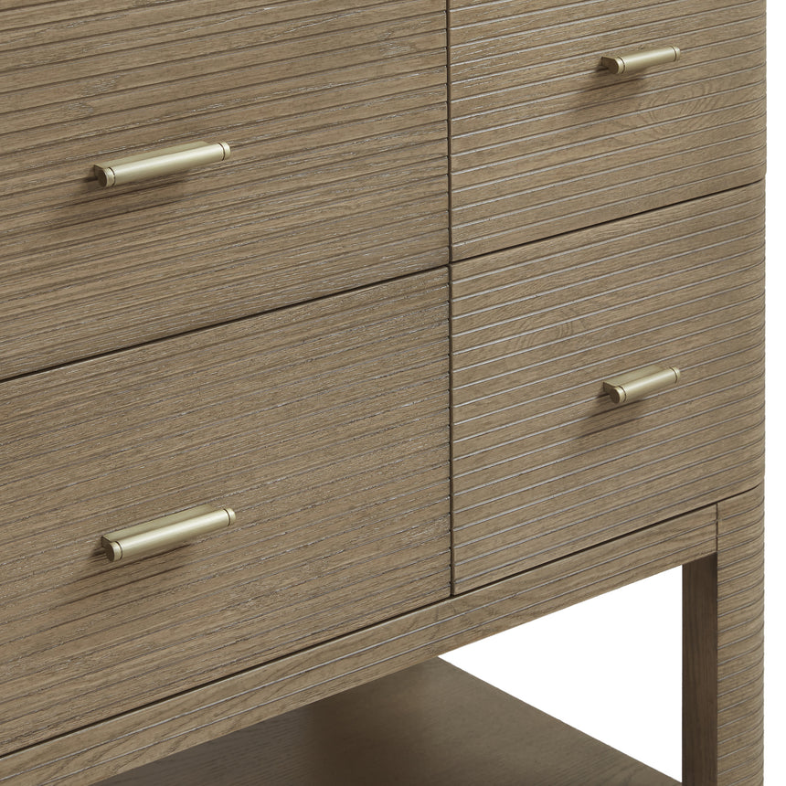 A modern bathroom vanity with a light oak wood frame, six drawers, an open lower shelf, and a white marble top with an integrated sink. The vanity is styled in a bright bathroom with a white freestanding tub, a gold faucet, and a glass shower stall in the background.