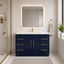 Bathroom with navy blue vanity, white countertop, and gold fixtures.