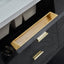 Close-up of a black drawer with gold handles and a wooden tray.