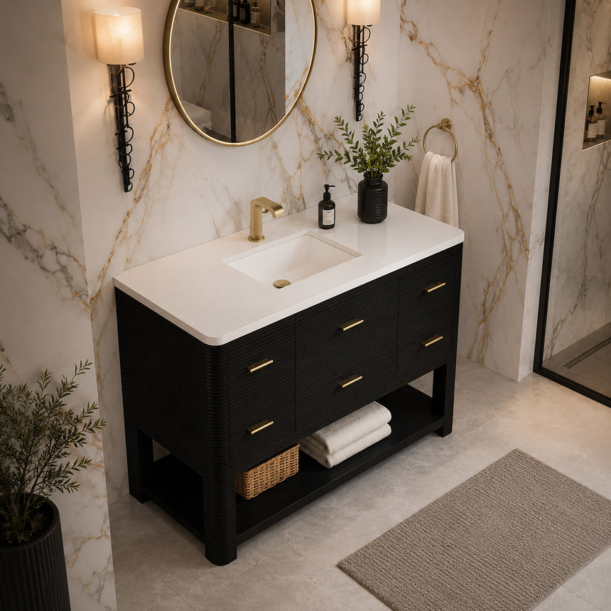 A modern bathroom vanity with a light oak wood frame, six drawers, an open lower shelf, and a white marble top with an integrated sink. The vanity is styled in a bright bathroom with a white freestanding tub, a gold faucet, and a glass shower stall in the background.