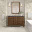 Bathroom vanity with mirror, sink, and decorative elements against a patterned wall.