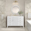 Bathroom with a white vanity, round mirror, and decorative elements.