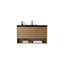 A modern wall-mounted bathroom vanity with a light oak wood slat cabinet, a black countertop, and an integrated sink with a matte black faucet. A folded white towel and small toiletry items are styled on the open lower shelf against a plain white background.