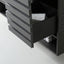 Close-up of a dark gray wooden drawer unit with one drawer pulled open, revealing a light gray textured cloth inside.