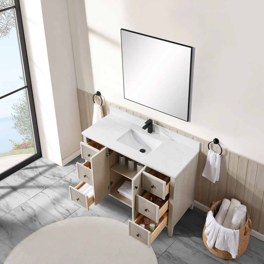 Bathroom vanity with double sink, mirrors, and towels in a well-lit room.