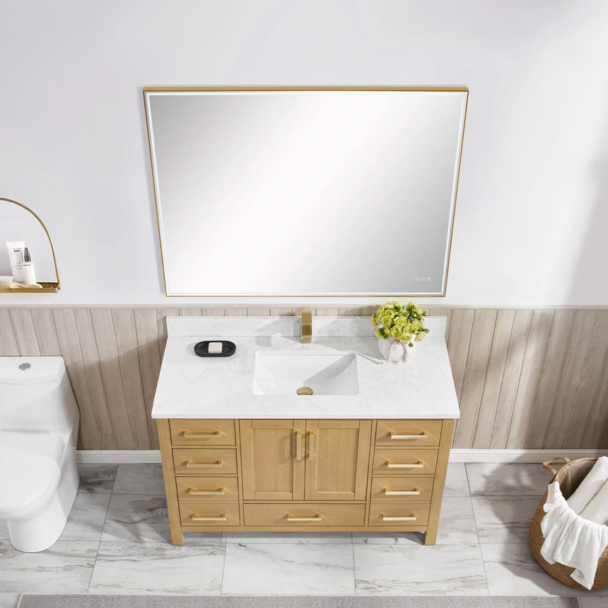 Bathroom vanity with wooden cabinets and white countertop, featuring a toilet and towel on the side.